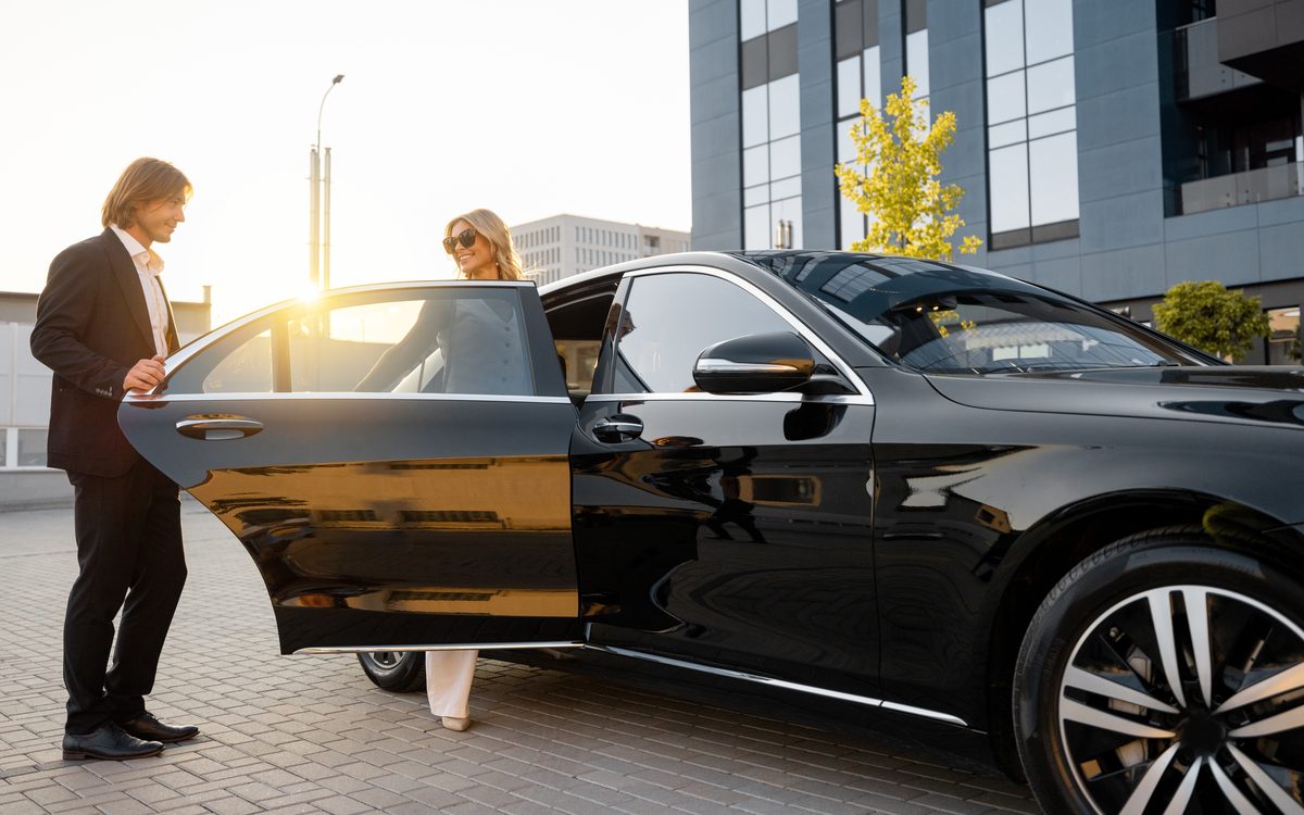Chauffeur opening the door of a corporate sedan